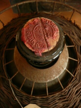 Antique French wine bottle/liquid container in original metal casing