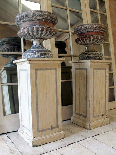 Pair of late Victorian urns sitting on later plinths