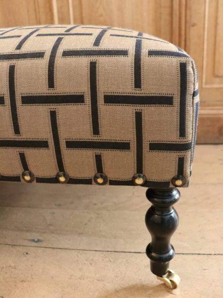 A classic antique ottoman on ebonised mahogany legs c.1900
