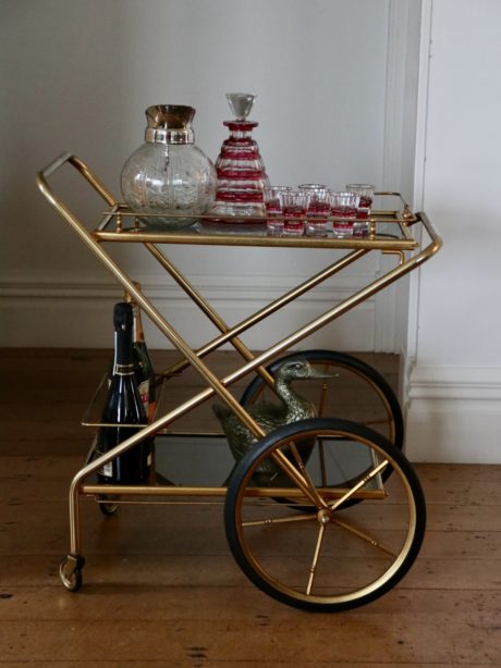 A smoked glass and brass nickel drinks trolley