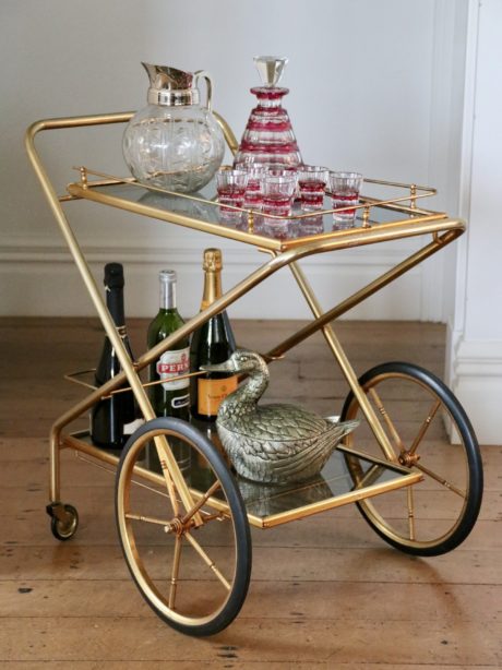 A smoked glass and brass nickel drinks trolley