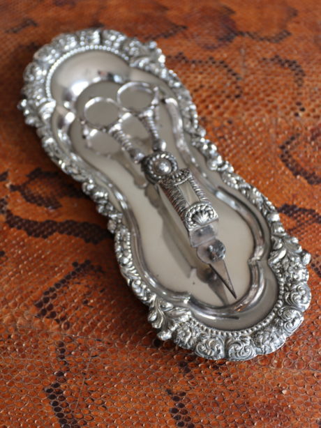 An antique silver plate candle snuffer with tray