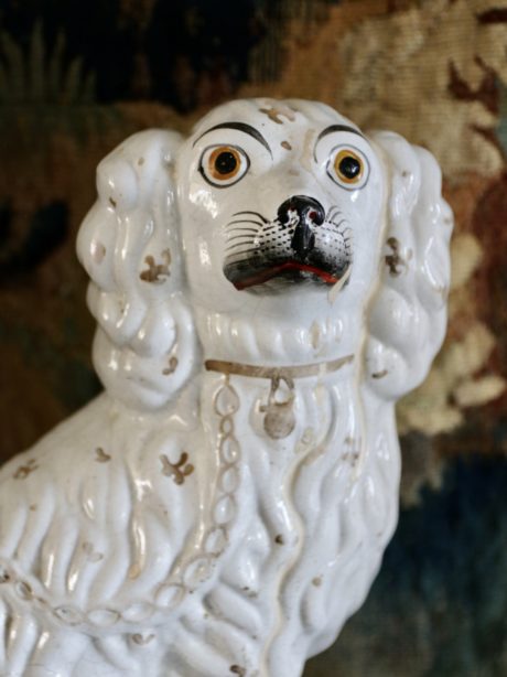An antique earthenware Staffordshire spaniel figurine