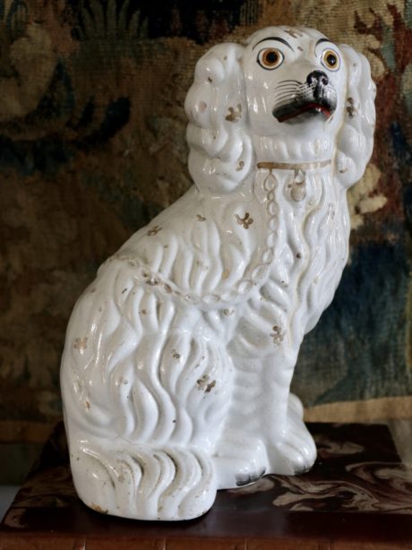 An antique earthenware Staffordshire spaniel figurine