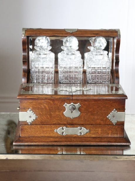 Antique English oak cased three decanter tantalus